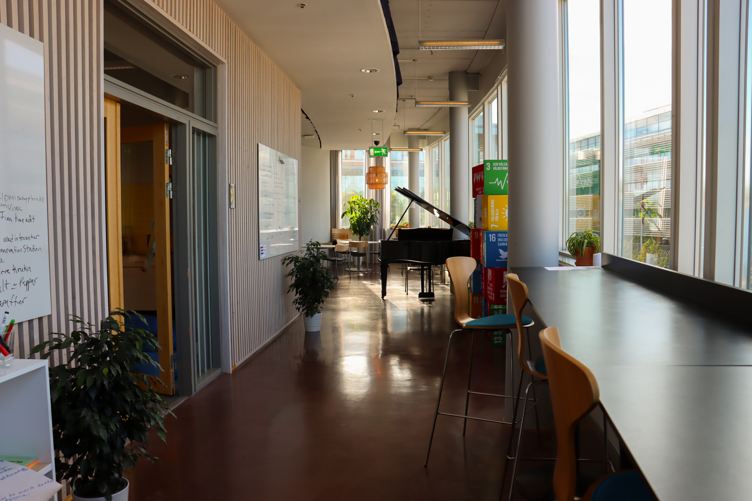 Korridorsbild hos Innovation Station Flemingsberg med stolar och flygel i bakgrunden