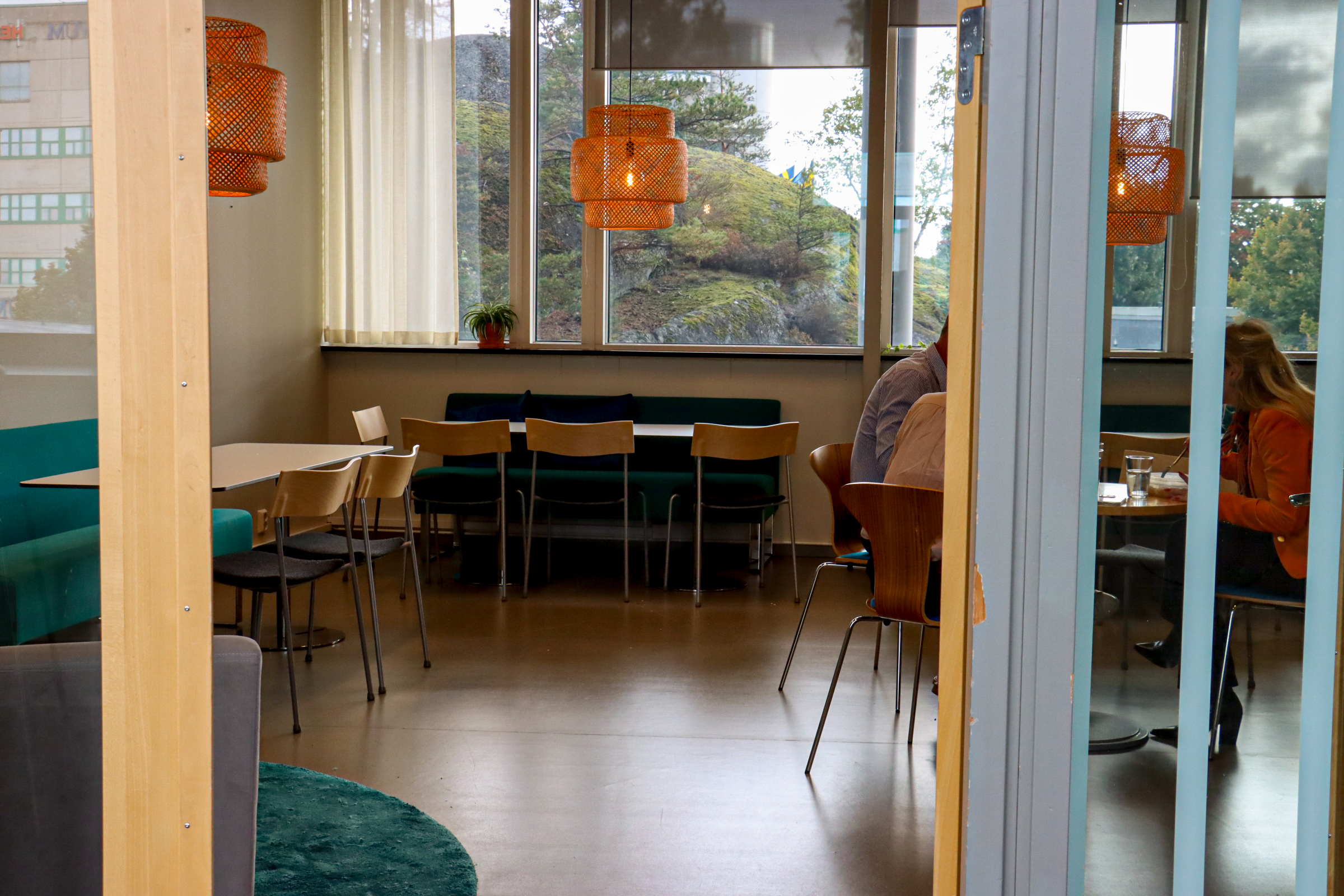 Pentrybild hos Innovation Station Flemingsberg med tre personer som äter lunch och tomma stolar